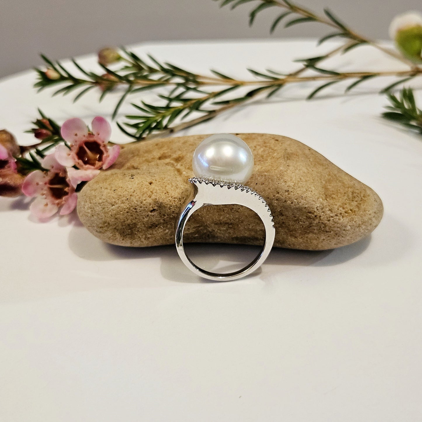 Pearl ring with sweeping diamond set shoulder