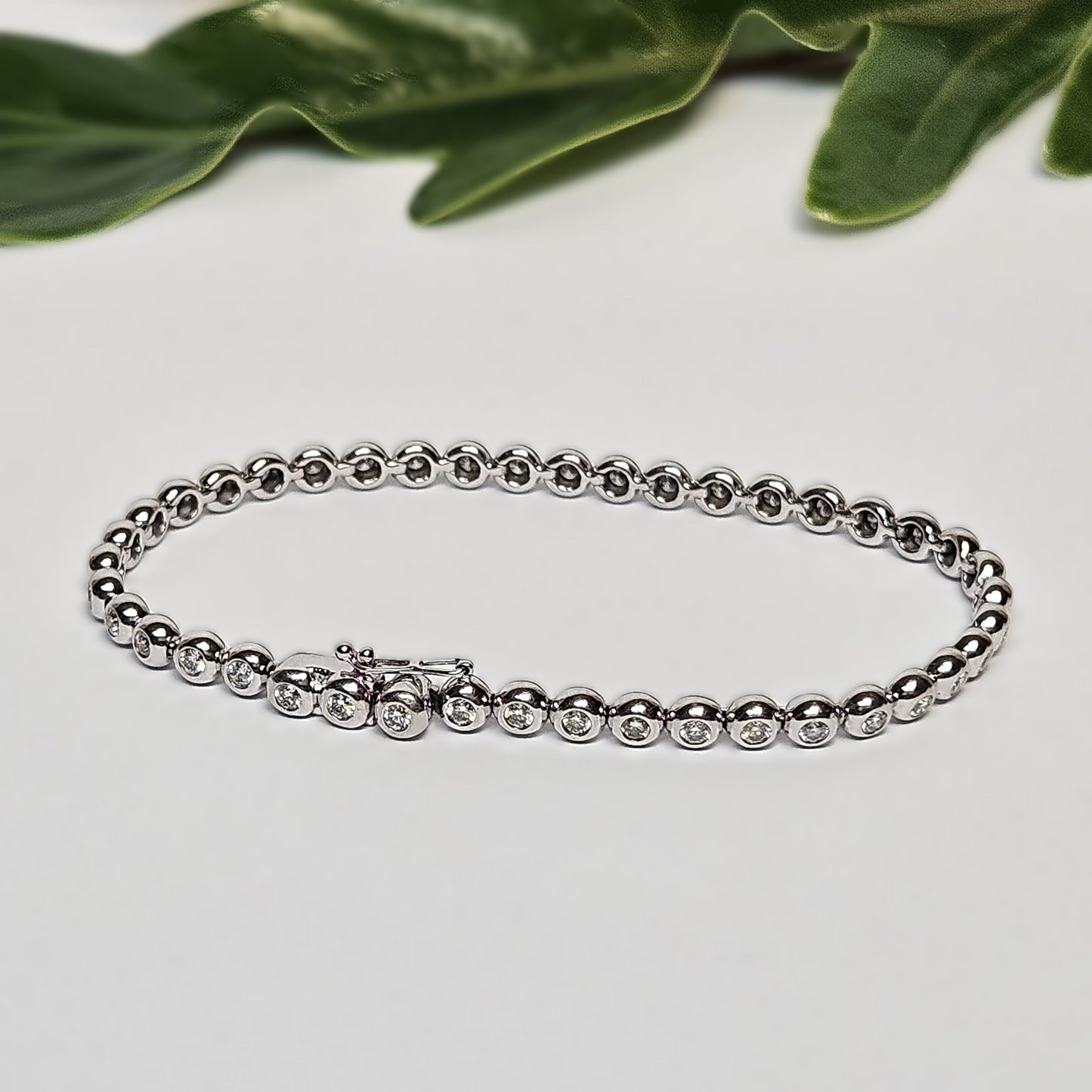 Tennis bracelet with rubbed in diamond settings
