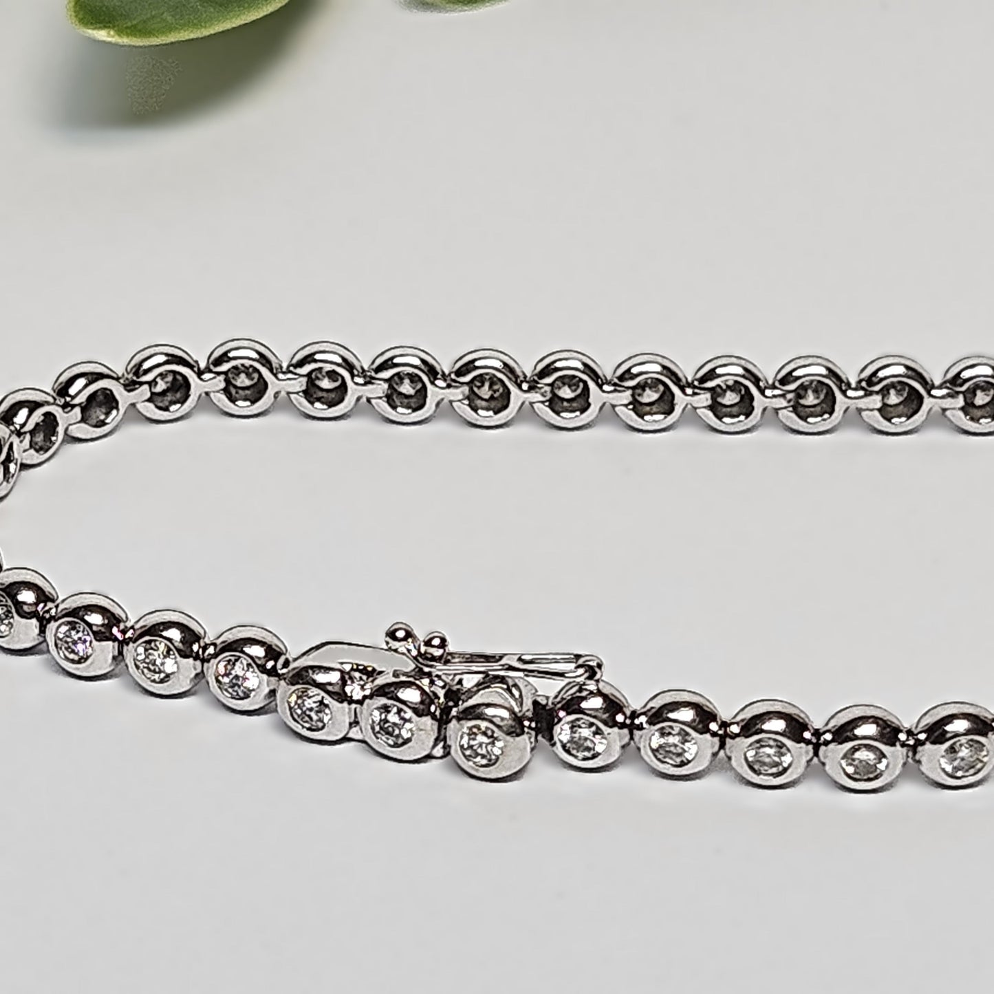 Tennis bracelet with rubbed in diamond settings