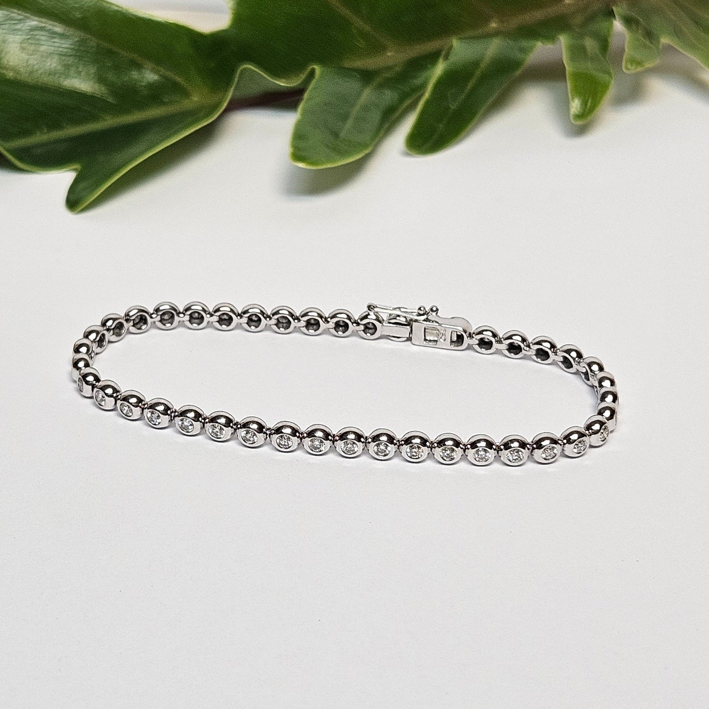 Tennis bracelet with rubbed in diamond settings